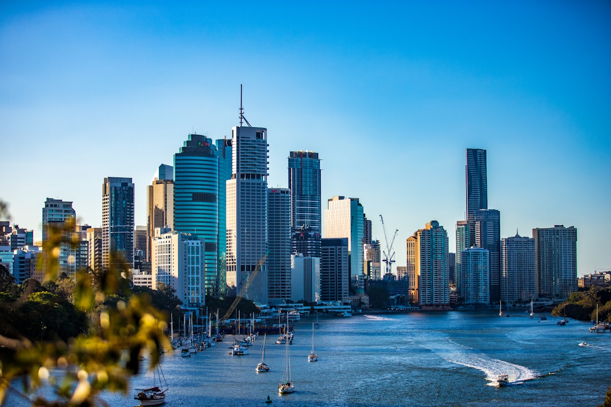 Brisbane city skyline and downtown buildings reflected against a clear blue sky viewed from the Brisbane River