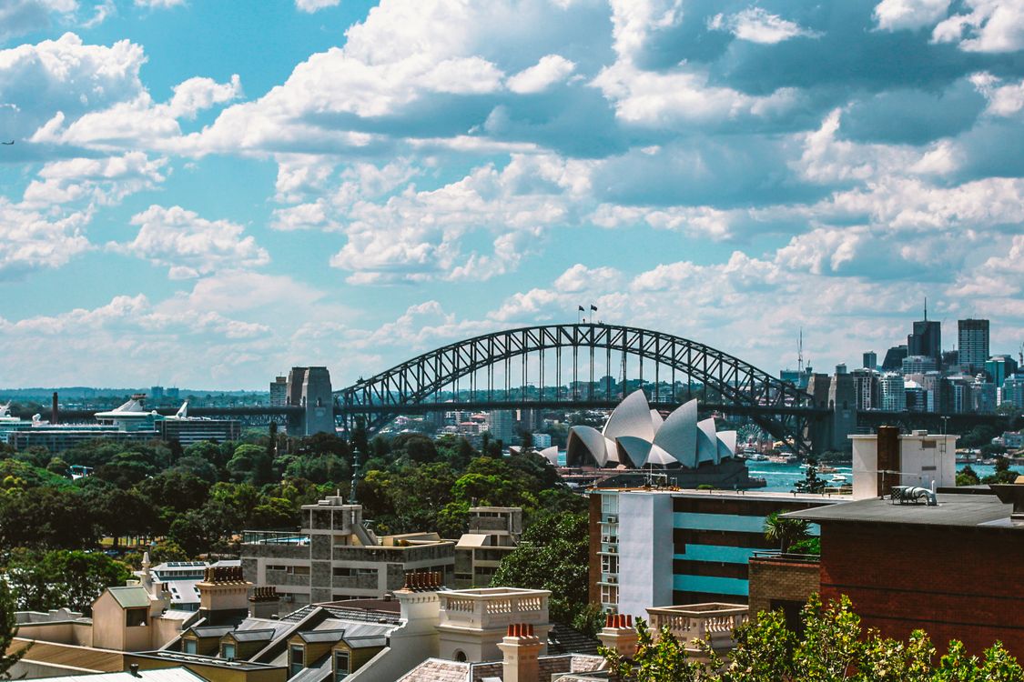 Aerial view of Sydney Harbour Bridge and Opera House at golden hour representing cannabis delivery across Australian cities