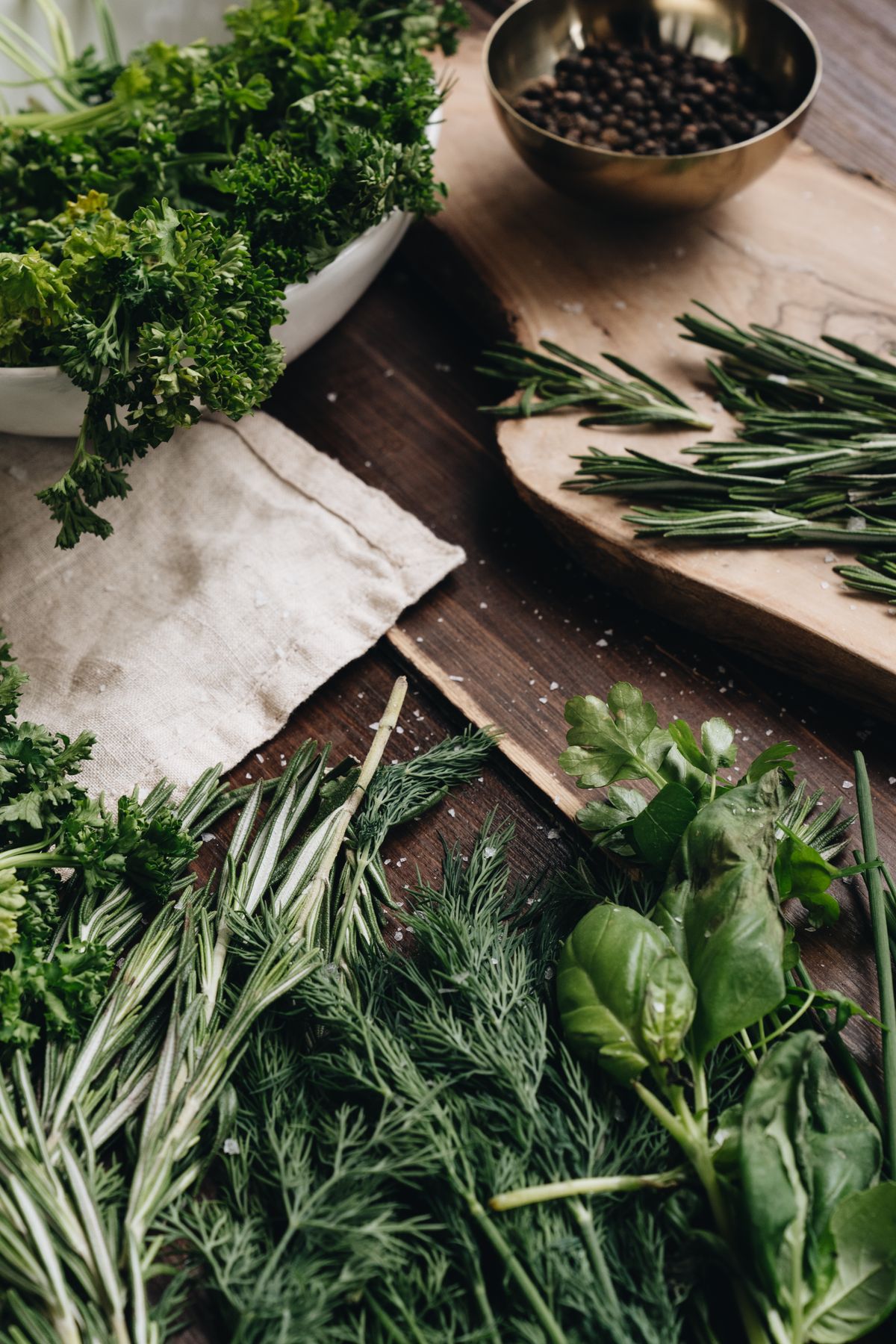 Fresh botanical herbs laid out on a wooden surface representing cannabis terpenes and their natural aromatic compounds